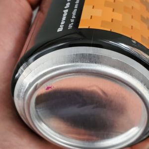 Close-up of a shrink-wrapped sleeve beer can label, bottom of can